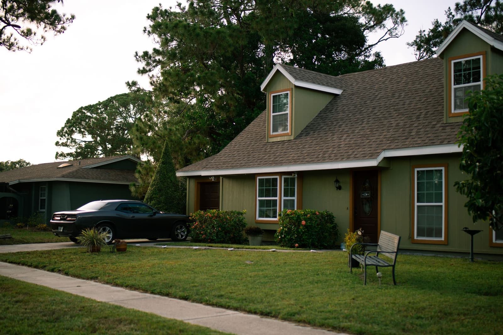 Green house with shingle roof and lawn