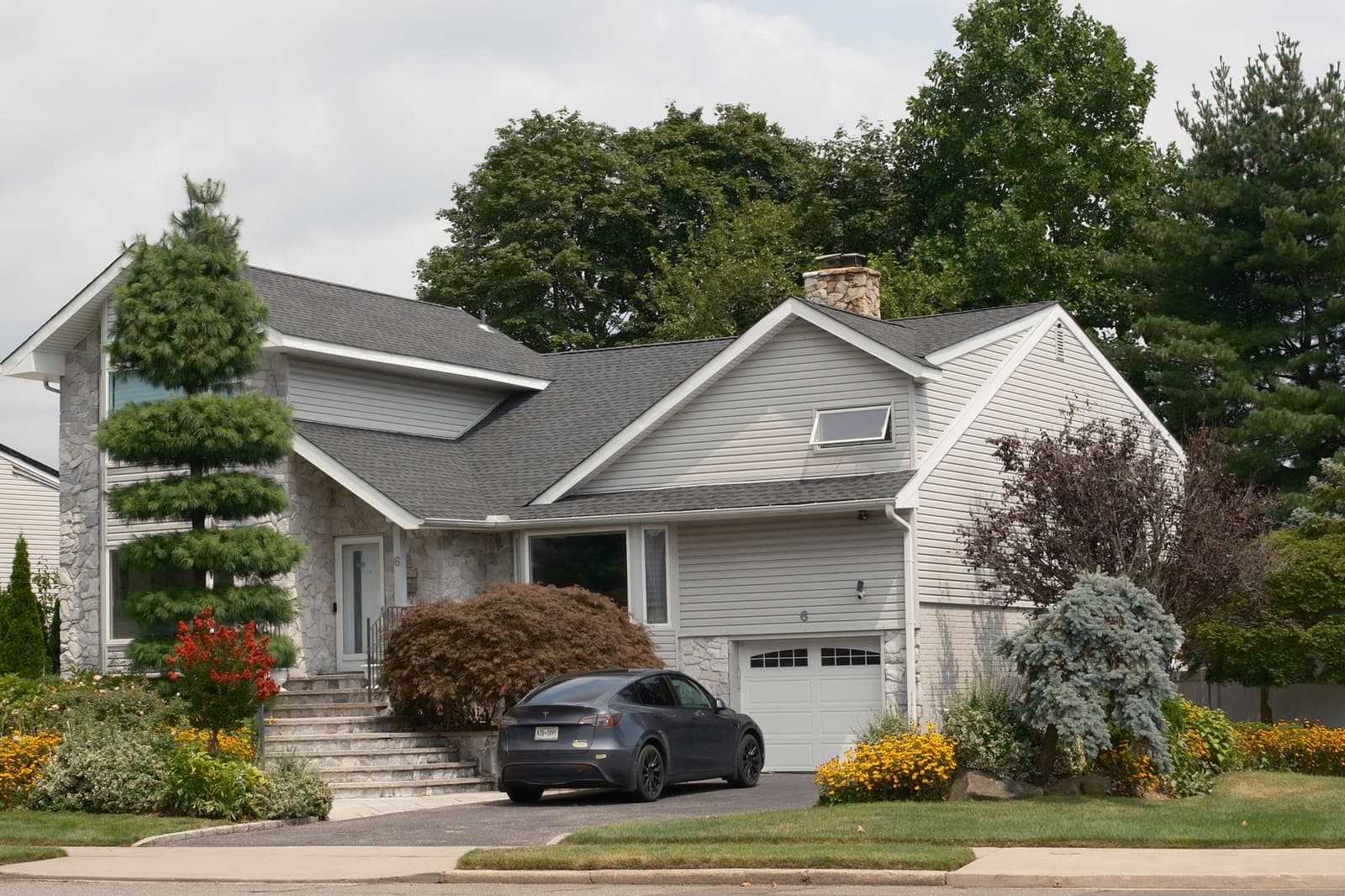 Modern house with gray shingle roof and landscaping
