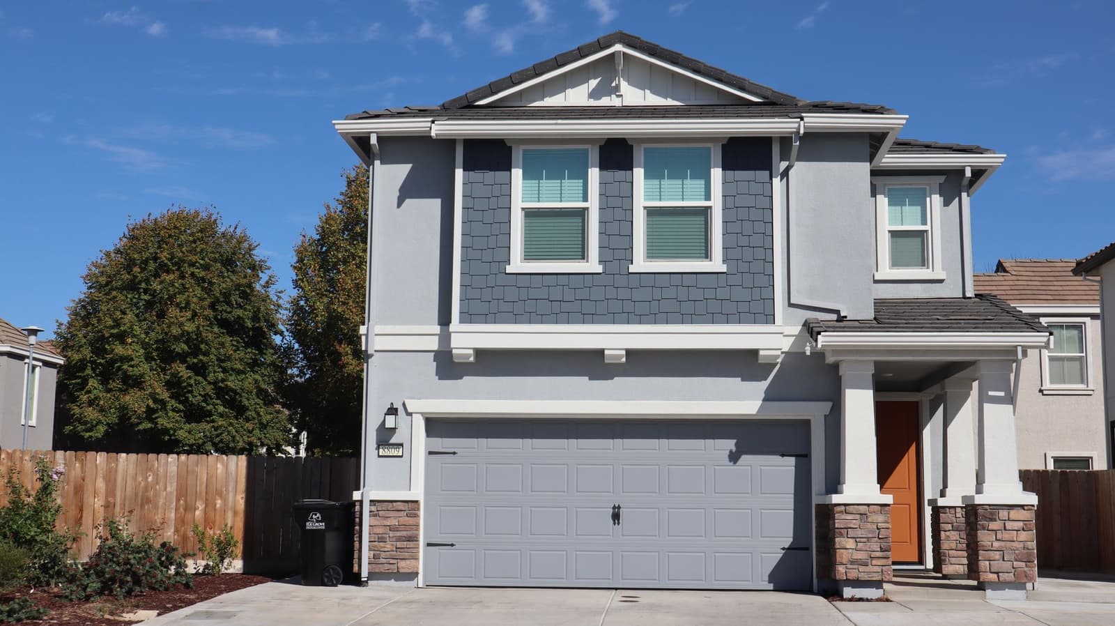 Gray two-story house with garage and shingle roof
