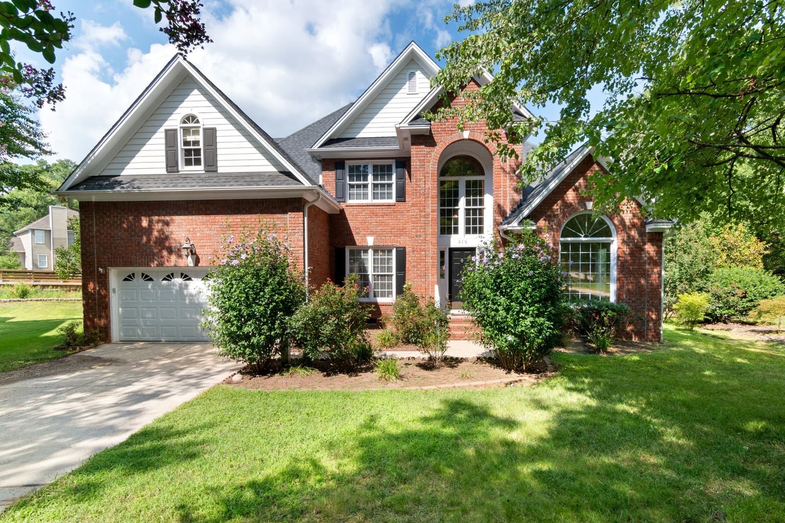 Brick house with shingle roof and garage
