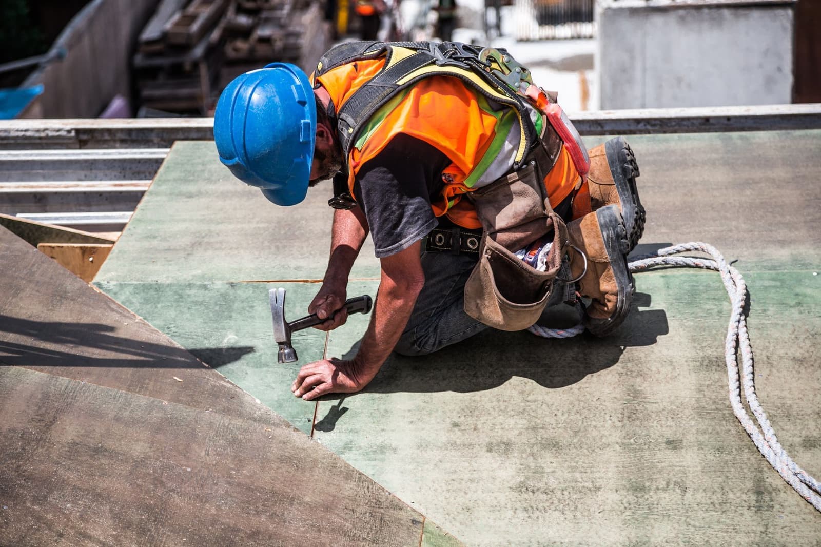 Roofer hammering on a roof deck