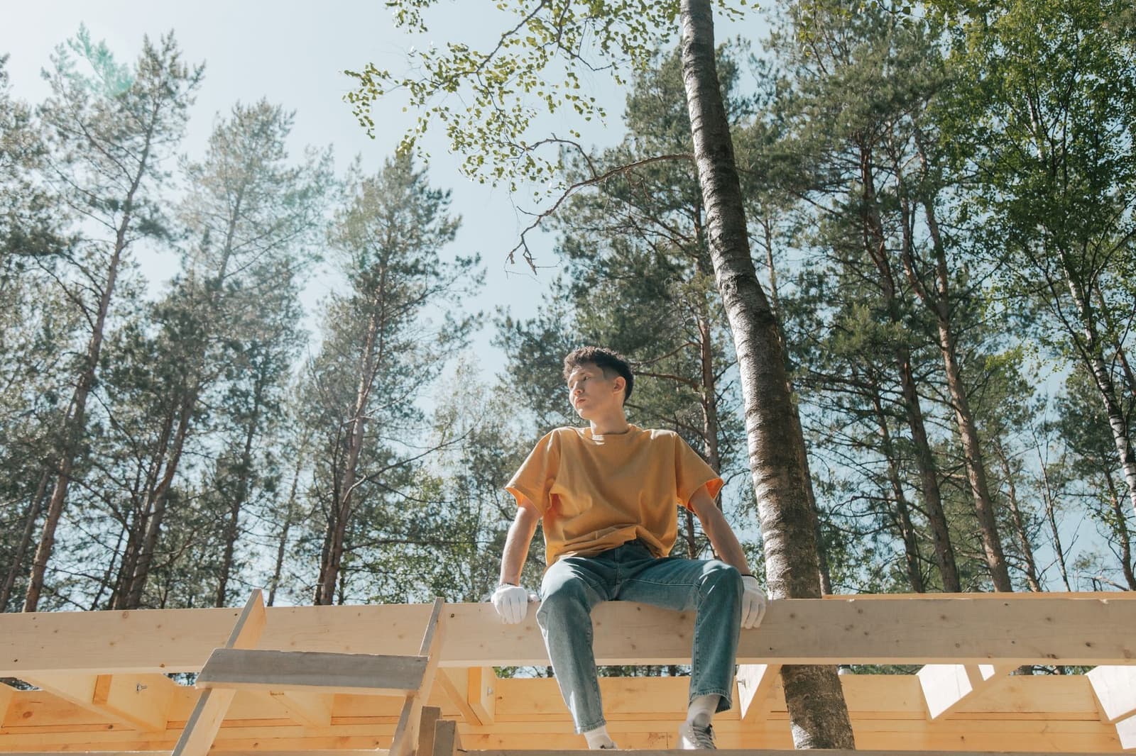 Worker sitting on a timber roof beam