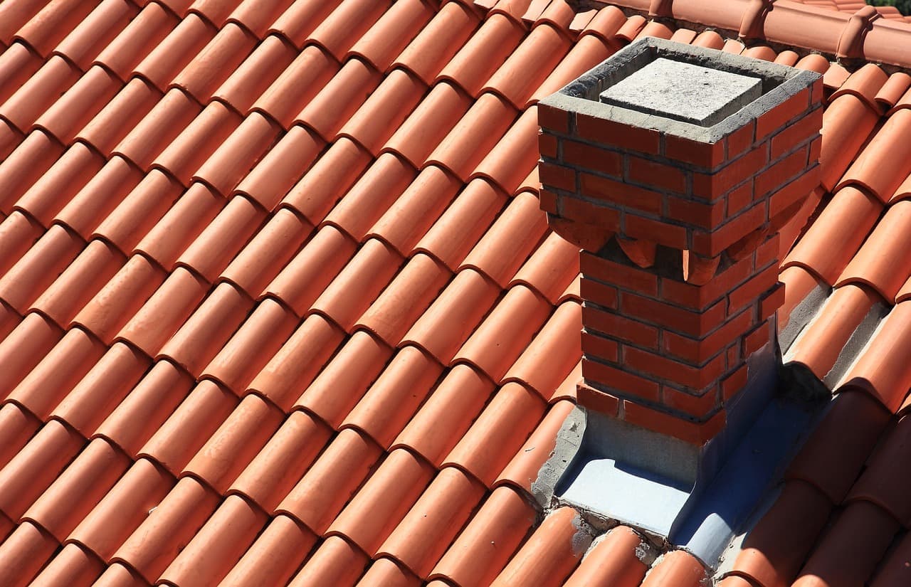 Red clay tile roof with brick chimney